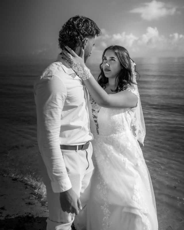 Black and white portrait of a bride and groom beside the sea